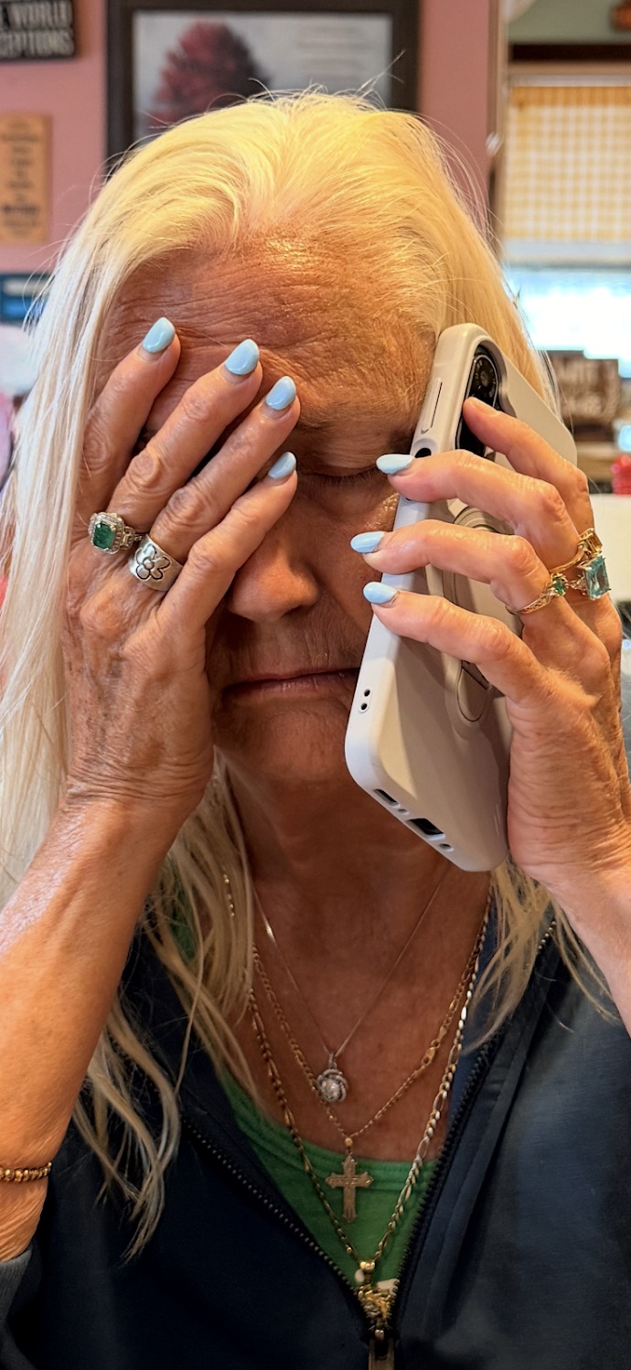 Penny holding a phone, with pale blue nails and jewelry